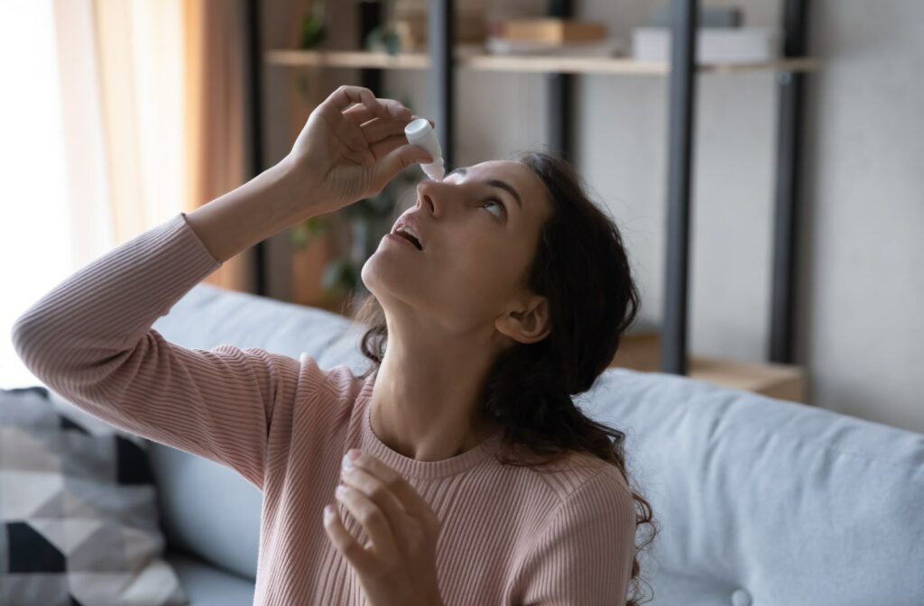 A woman using Restasis eye drops to soothe her eyes