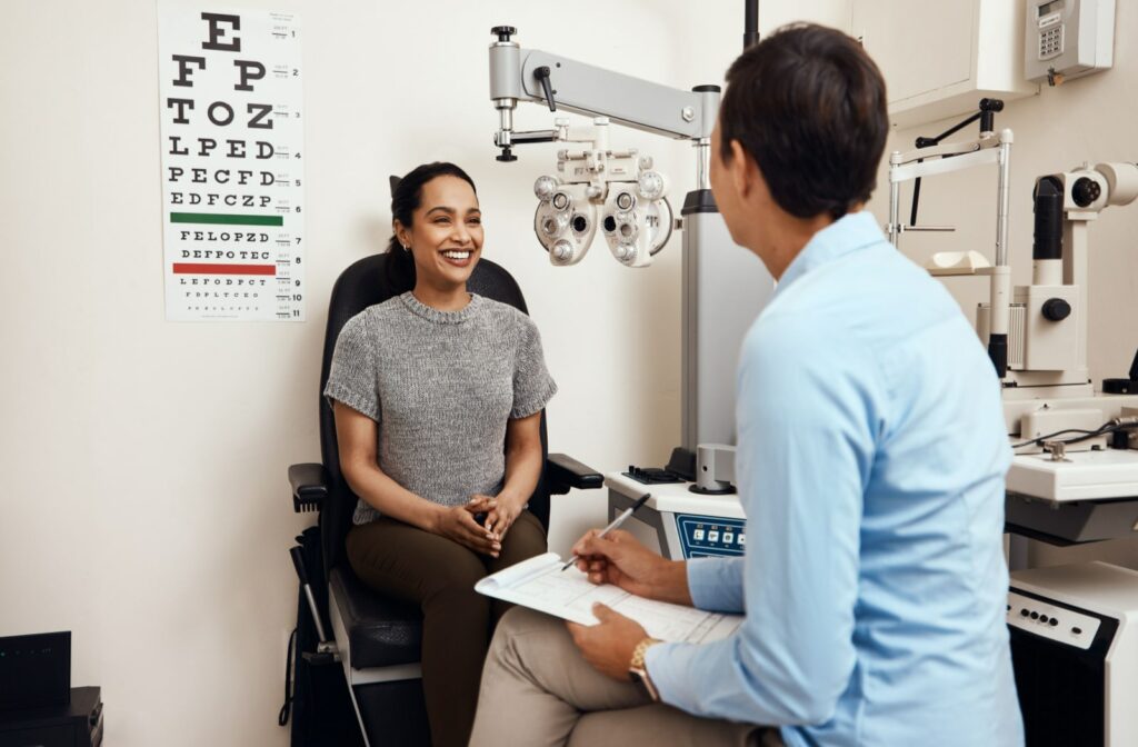 A woman sitting in a chair at the optometrist's office, discussing her health and vision with a male optometrist