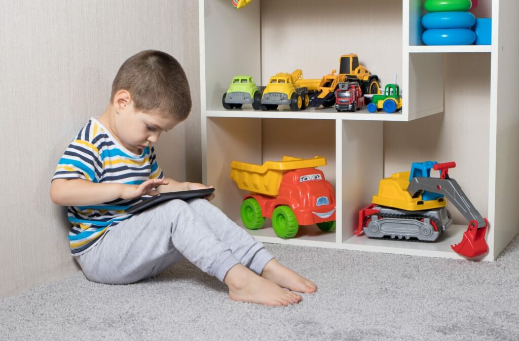 Little boy with myopia staring closely at his tablet