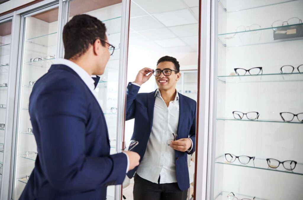 A young professional tries on several eyeglass frames in search of a pair that feels and looks just right.