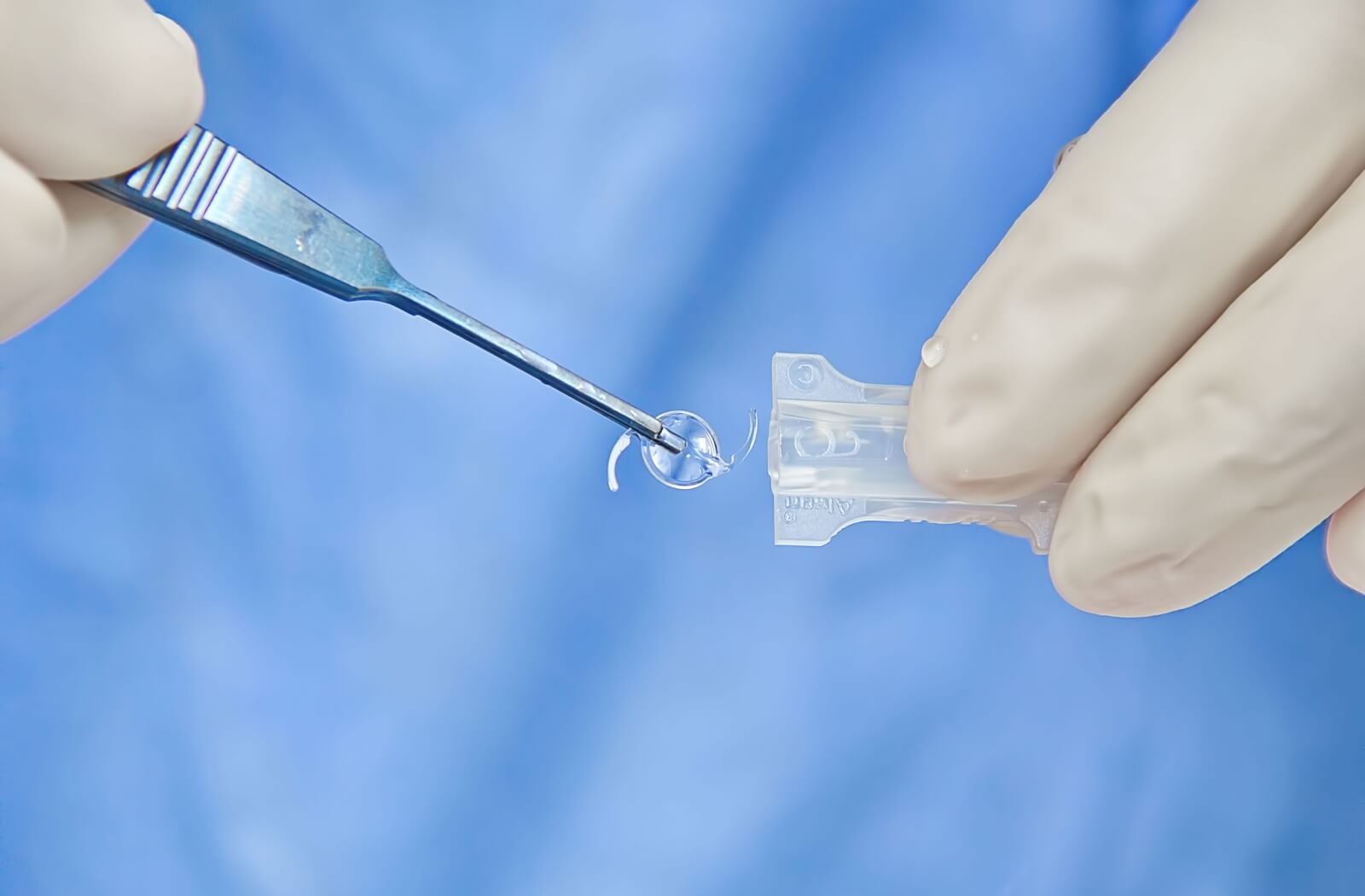 A close-up image of doctor getting an intraocular lens ready during cataract surgery.