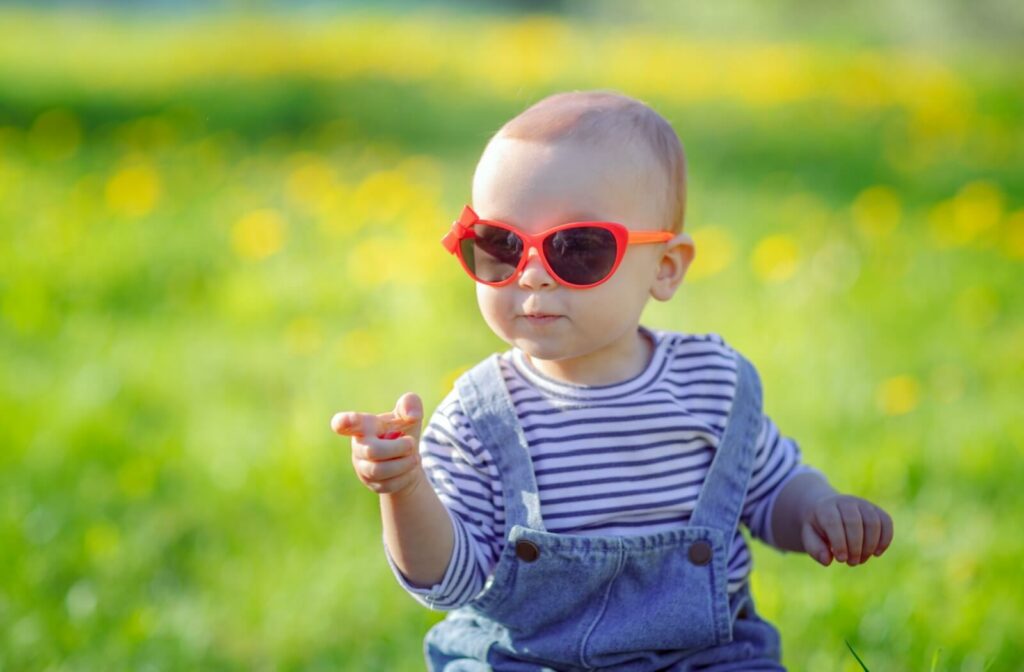 A portrait image of a baby wearing cute orange sunglasses.